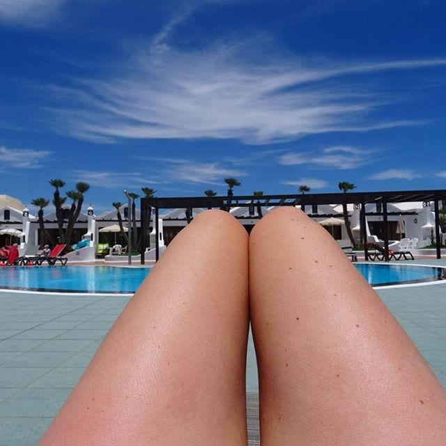 lady sunbathing on a sunny day by pool