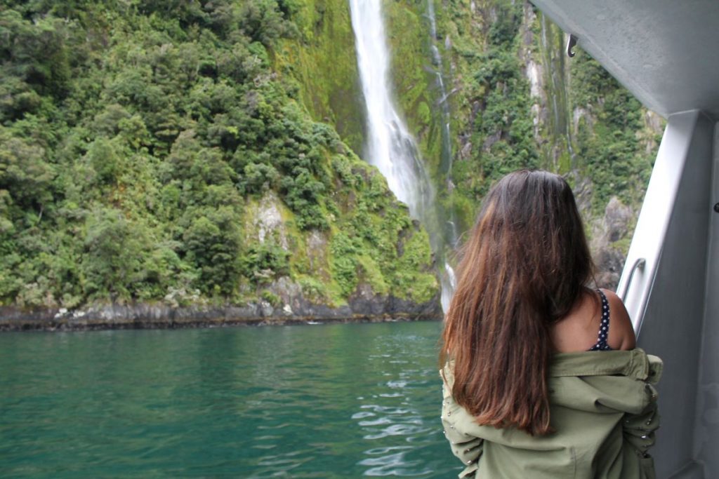 lady at waterfall on milford cruise