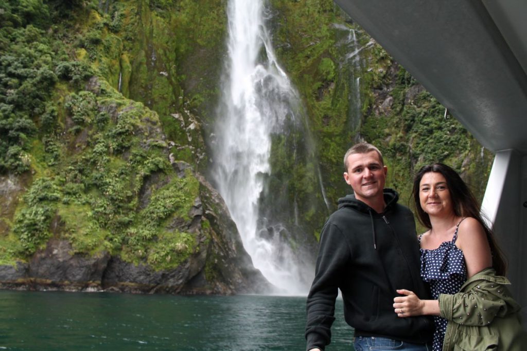 couple at milford cruise waterfall