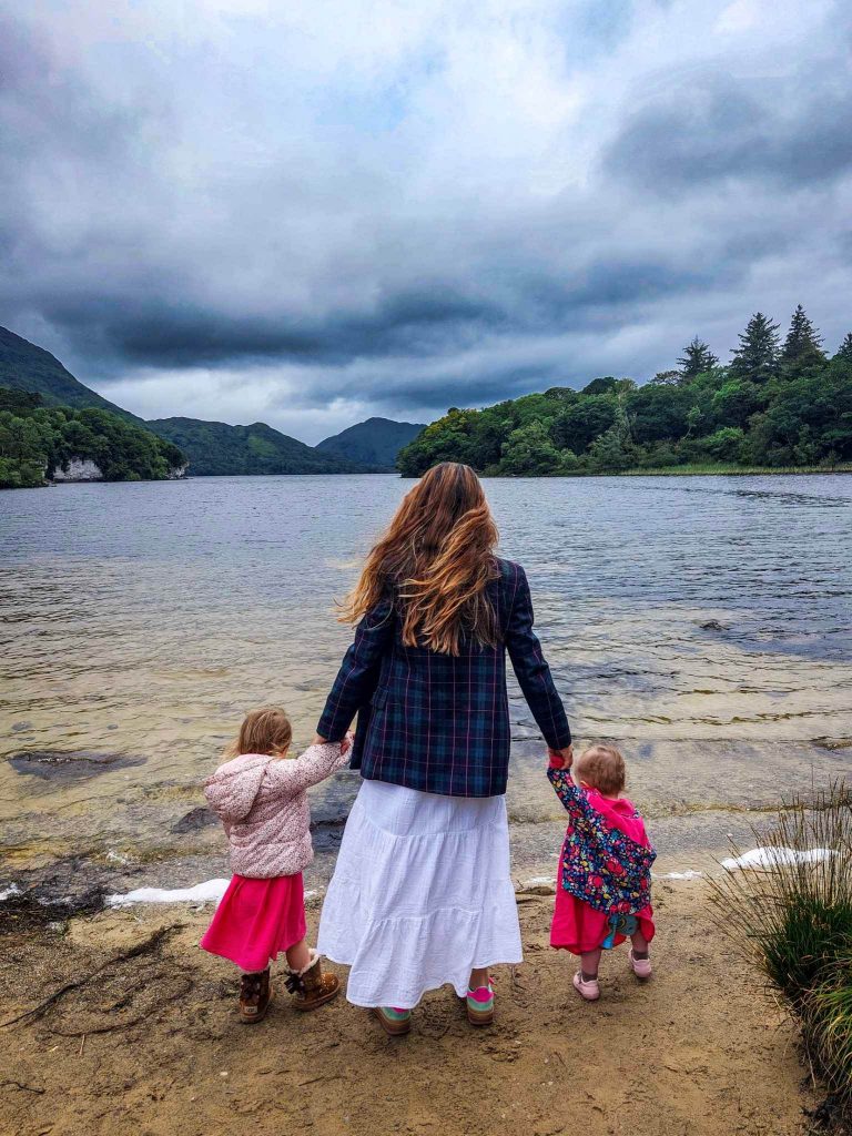 family pose on killarney national park lakefront 