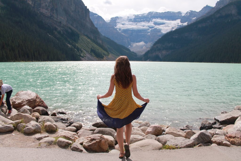 girls poses on lake louise lakefront 