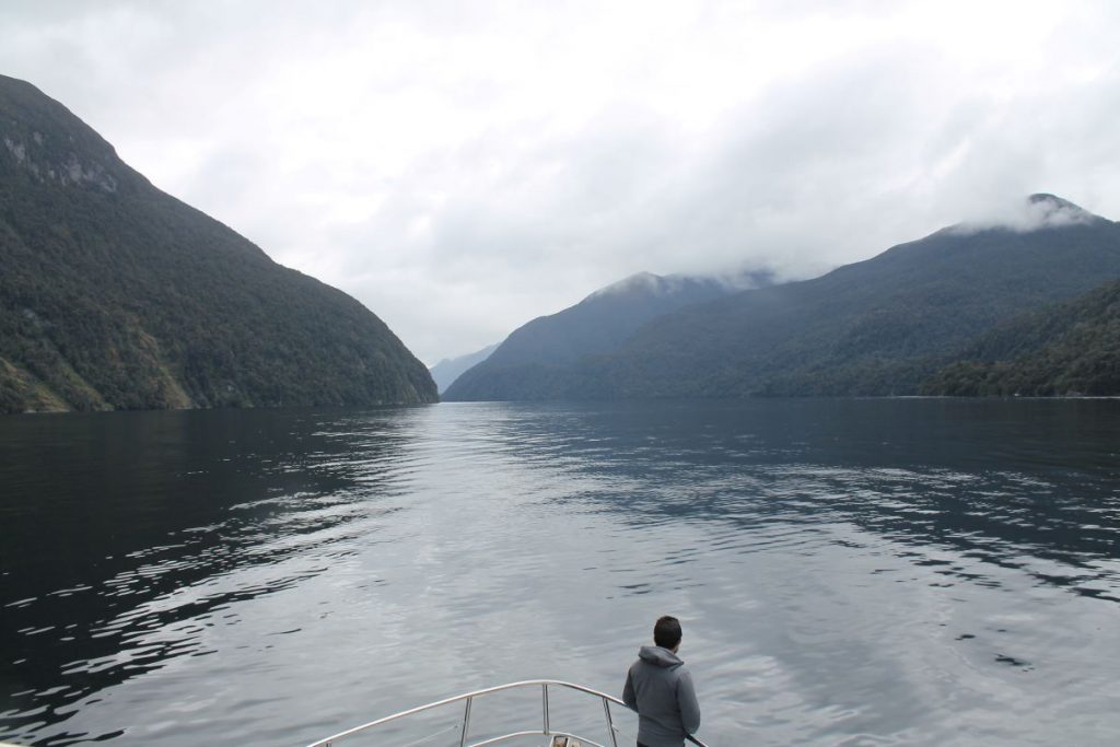 man poses at front of doubtful sound boat