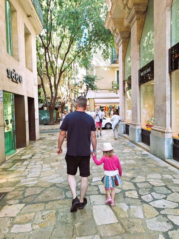 dad and daughter walking on paseo del borne