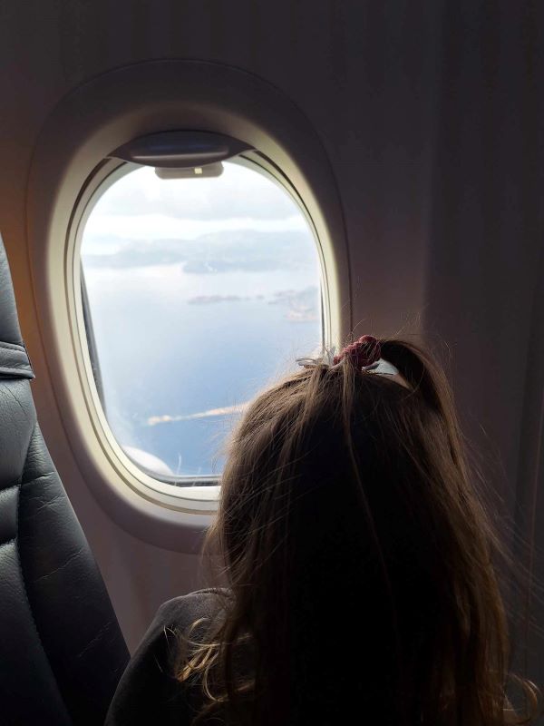 girl looking our plane window