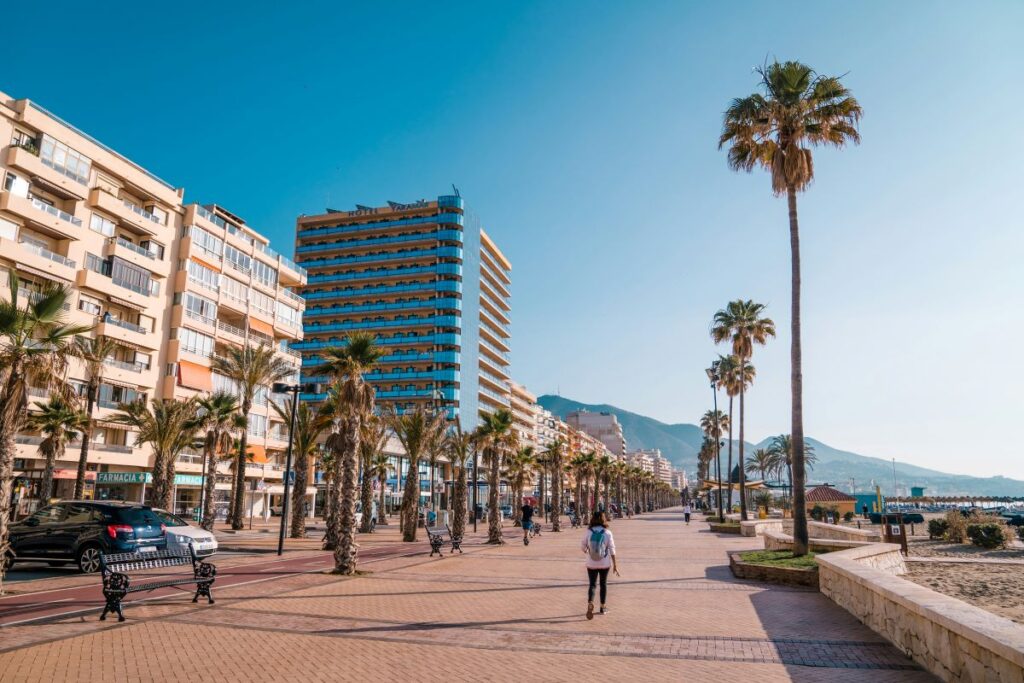 man walks down fuengirola promenade sunny day