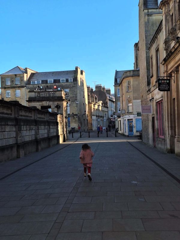 girl running quiet street bath